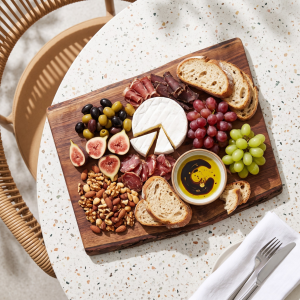 Wooden charcuterie board with cheeses, cured meats and a bowl of Wilson's Extra Virgin Olive Oil dip